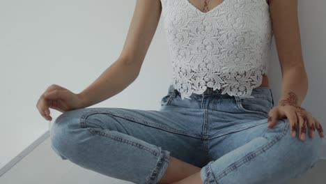 mujer sentada en la parte superior recortada y vaqueros con tatuaje de henna