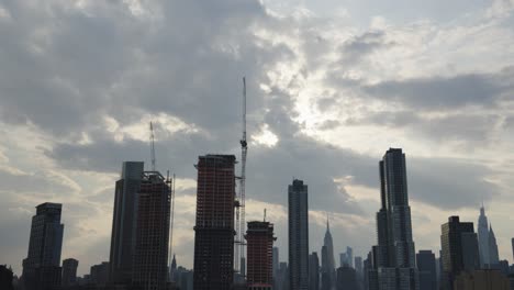 el lapso de tiempo revela nubes celestiales que se separan sobre un sitio de construcción de rascacielos en manhattan