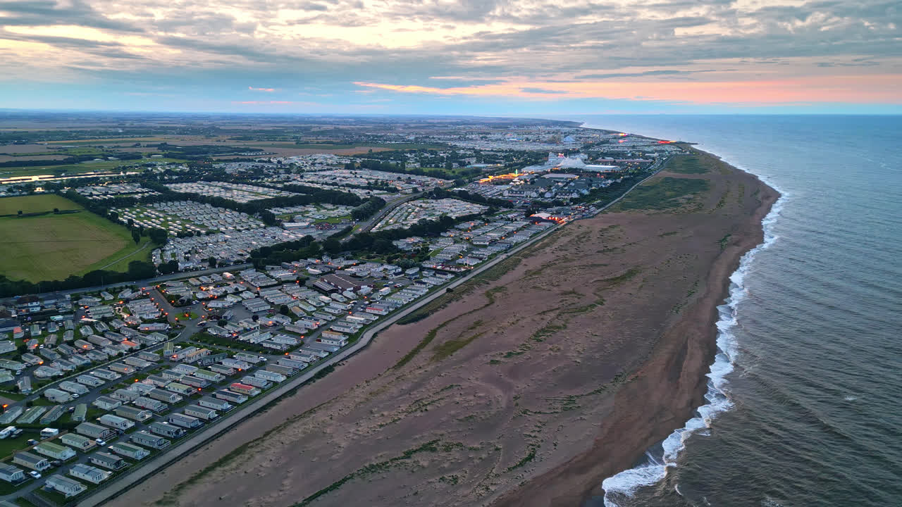 исследовать skegness через потрясающее видео дрона на закате, выделяя парк отдыха, караваны, море и пляж