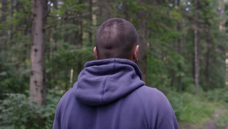 hombre ajustando auriculares en el bosque