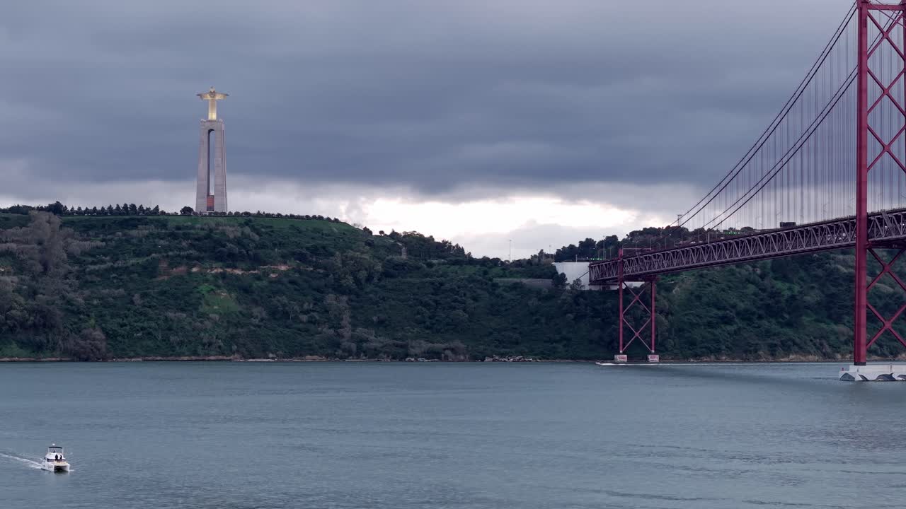 Santuario di Cristo Re vicino al ponte sospeso Ponte 25 de Abril sotto un cielo coperto sull'estuario del fiume Tago al tramonto, Lisbona, Veduta aerea