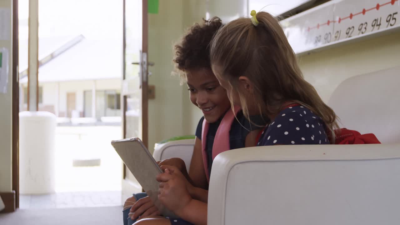 Two girls using digital tablet in the class