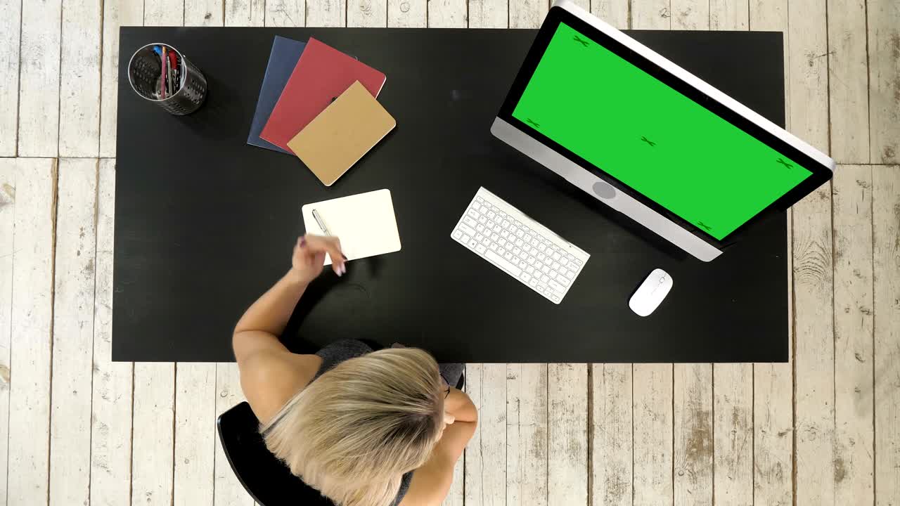 Young beautiful woman working and talking with smart phone and using computer. Green Screen Mock-up Display