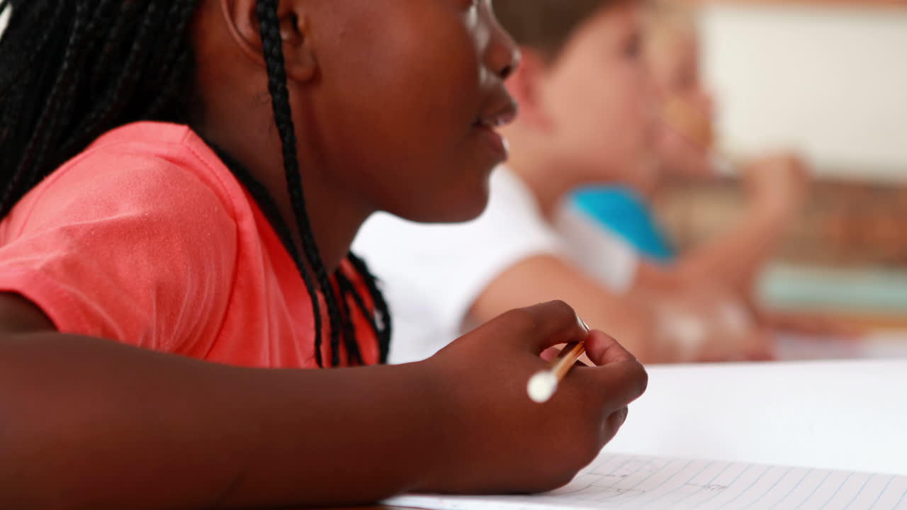 Little girl writing during class