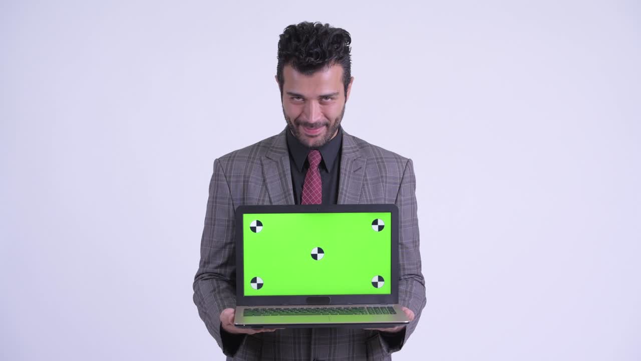 feliz guapo hombre de negocios persa barbudo con computadora portátil