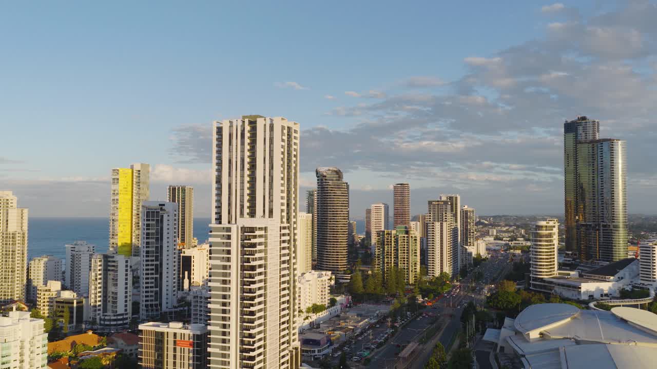 Drone footage captures Gold Coast's skyline with skyscrapers, ocean views, and vibrant city life during sunset