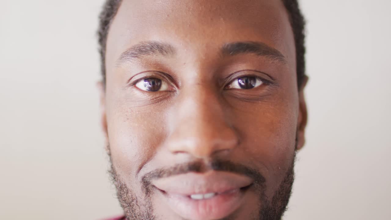Ritratto di uomo afroamericano felice che guarda l'obbiettivo e sorridente