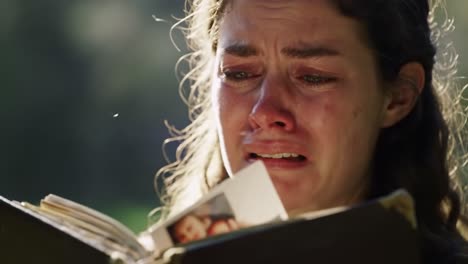a heartfelt moment: a young woman overwhelmed with emotion as she reads from an old book, tears streaming down her face in a reflection of deep connection and memories