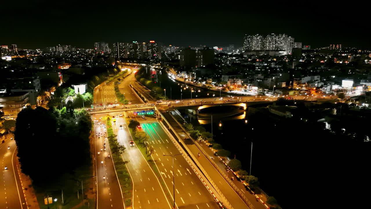 Stunning aerial view of vibrant night traffic flowing through a bustling highway junction, illuminated by glowing city lights. Perfect for urban, transportation, or time-lapse projects