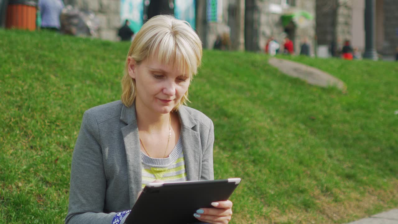 молодая женщина отдыхает в парке с цифровым планшетом 4k видео