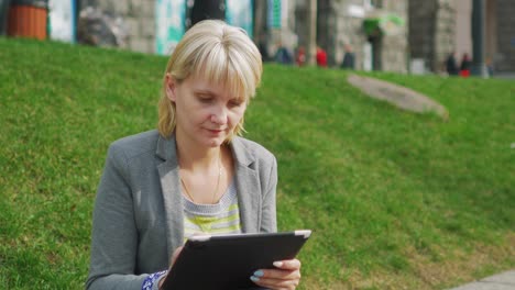 Junge-Frau,-Die-Sich-Im-Park-Ausruht,-Genießt-Ein-Digitales-4k-Tablet-Video