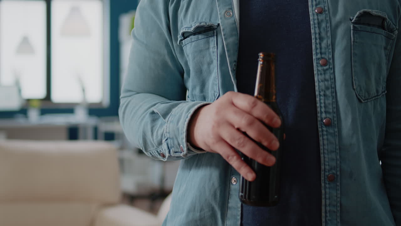 Portrait of businessman holding bottle of beer after work in office