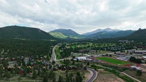 Drone-ascends-along-winding-road-into-Estes-Park-Colorado-in-valley-of-Rocky-Mountains