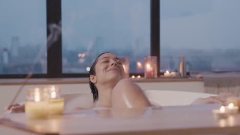 욕조 1에서 목욕하는 여성을 배경으로 촛불을 가까이서 볼 수 있습니다.