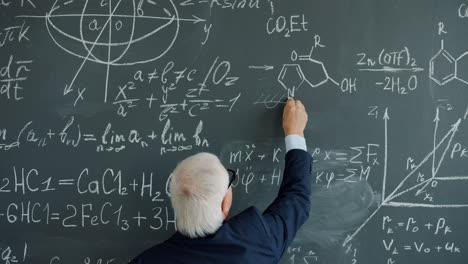 Professor writing equations on a chalkboard