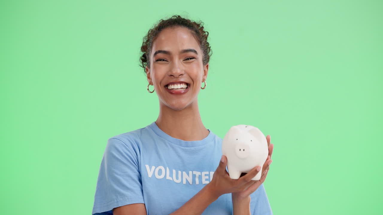 Volunteer holding a piggy bank, smiling