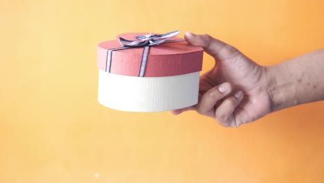 hand holding a heart-shaped gift box