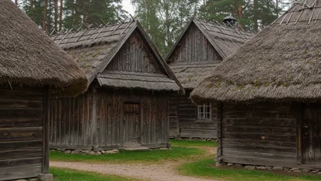 a serene village scene featuring traditional wooden houses with thatch roofs surrounded by lush greenery in a peaceful natural setting