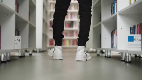 person walking in a library