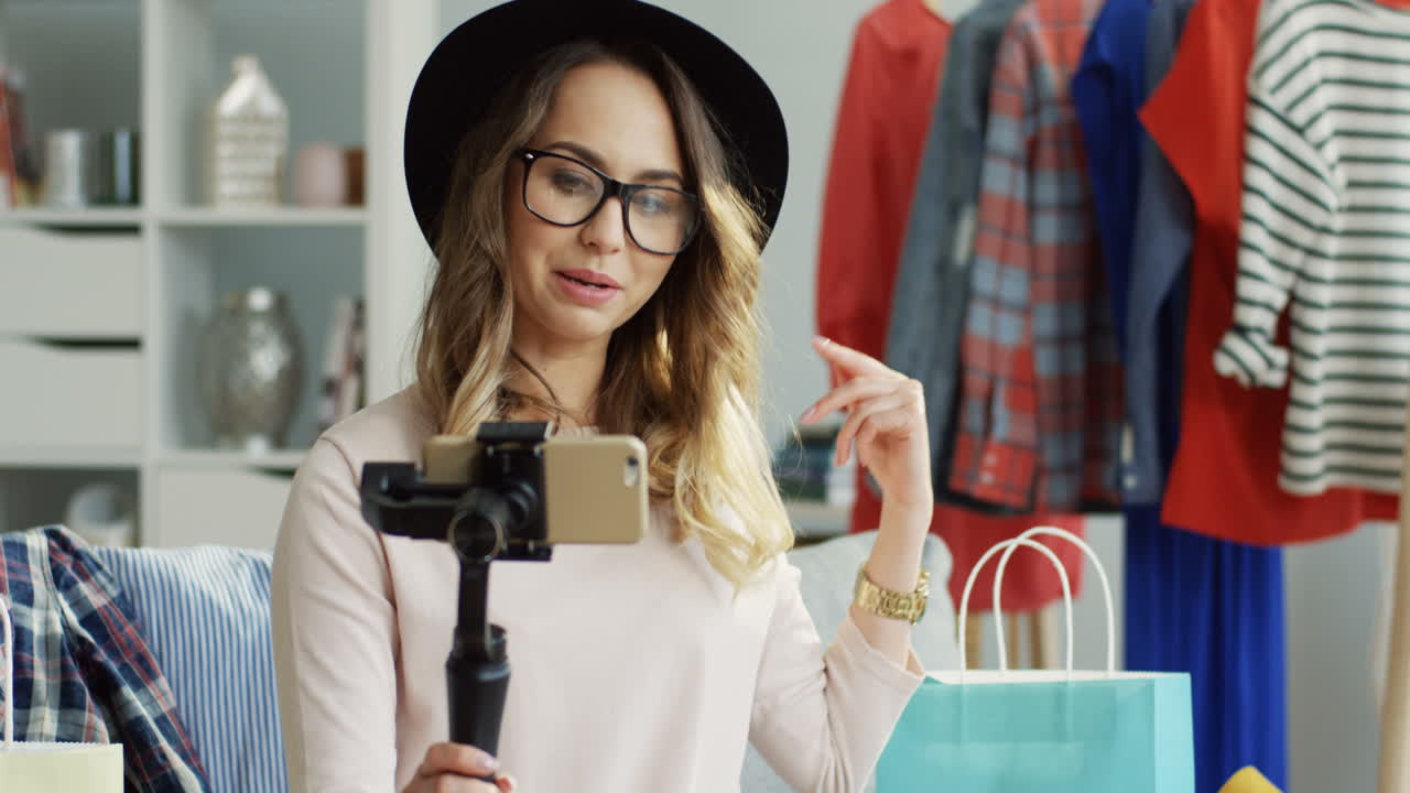 primer plano de una elegante influenciadora grabando un video con un selfie stick para su blog de moda