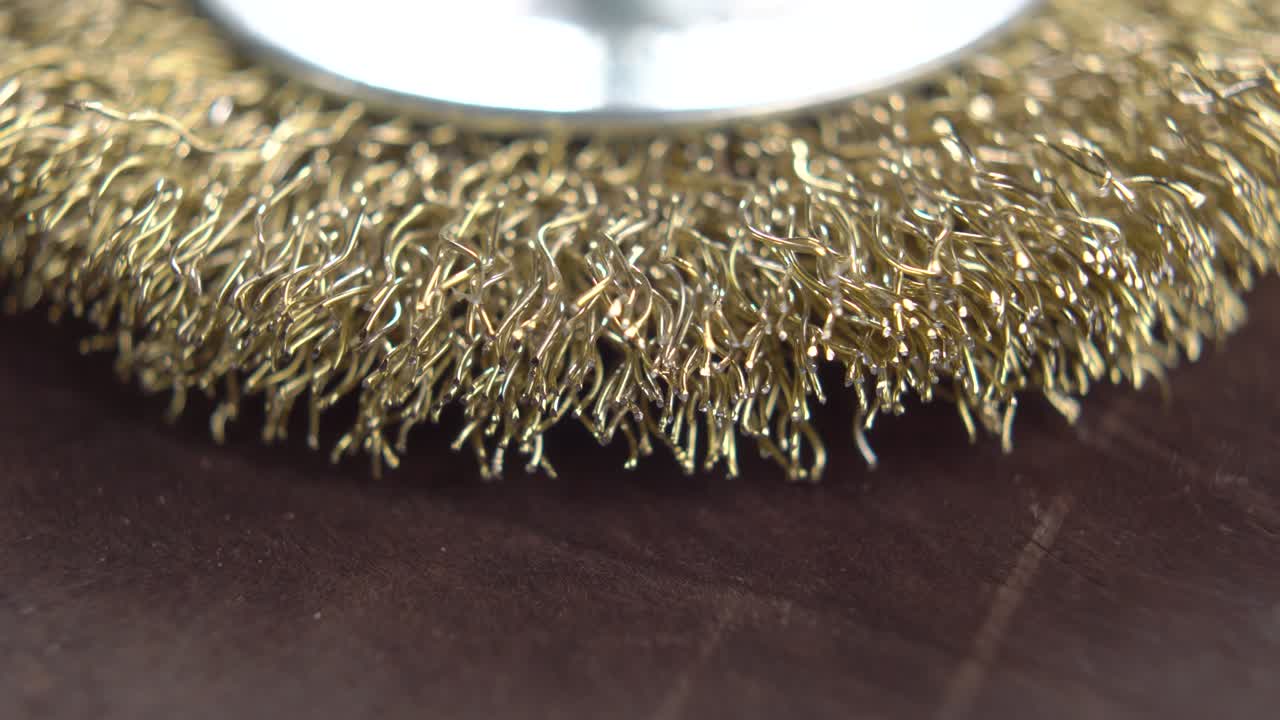 nuevo cepillo de alambre de bronce para taladro en superficie de madera. macro