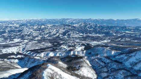 Side-tracking-shot-of-mountain-region,-shot-from-above-Mt-Myoko