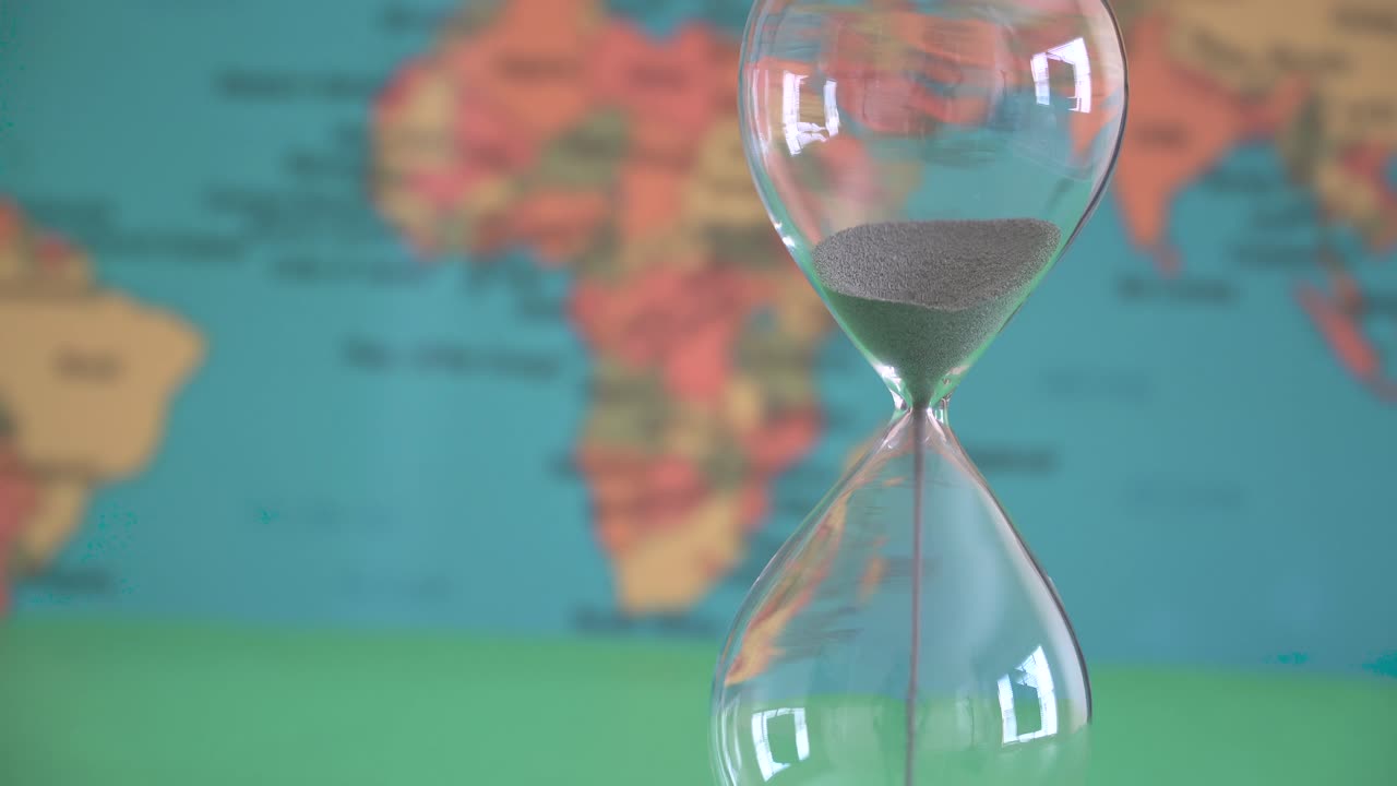 Cambiamento climatico e altri eventi mondiali distruttivi, come illustrato da una clessidra.