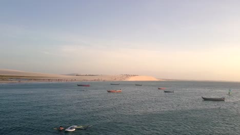 Drone-shot-above-boats-drifting-on-the-shore-of-Jericoacoara,-Brazil