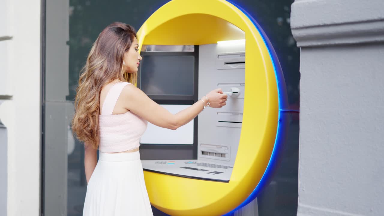 Woman inserting her card into an ATM for a financial transaction