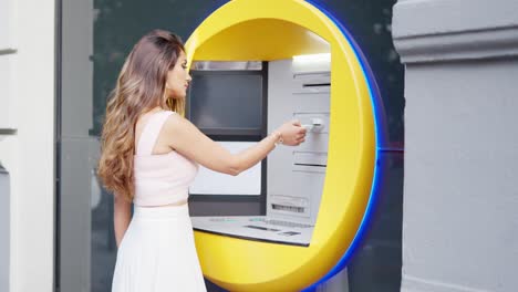 woman inserting her card into an atm for a financial transaction
