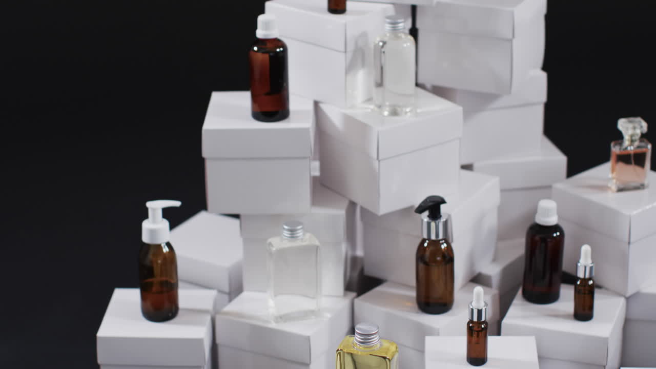 Video of beauty products with white cardboard boxes with copy space over black background