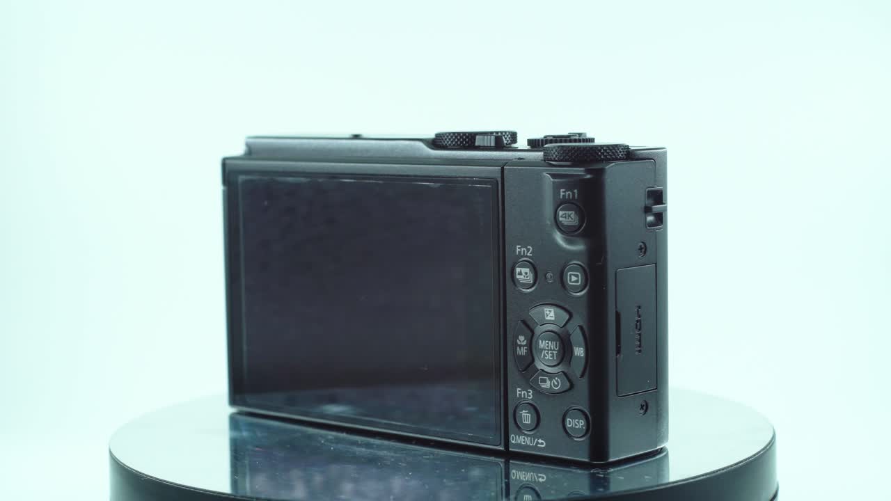 작은 검은색 포켓 카메라, 내장 알루미늄, 기능 버튼, 스튜디오 조명, 반짝이는 렌즈, 360도 회전 스탠드, 슬로우 모션, 4k 비디오의 클로즈업 샷