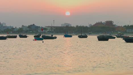 Static-shot-of-boats-floating-in-Da-Nang-during-a-vibrant-sunset