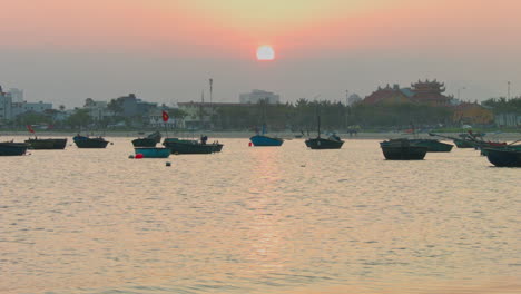 Toma-Estática-De-Barcos-Flotando-En-Da-Nang-Durante-Una-Puesta-De-Sol-Vibrante