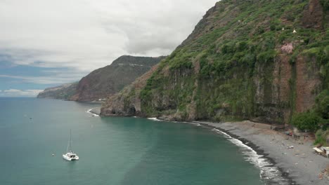 perfect cove with green overgrown cliffs and beautiful blue ocean water, aerial