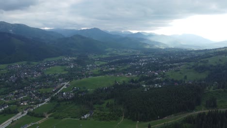 epic sky and valley view from gubałówka - landscape flyover of snowcapped polish tatry mountains, farmland, forests, and legendary giewont peak near zakopane, poland - 4k 30fps static