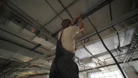 installation of electrical wiring on the ceiling.electrical cable system installation. electrician repairing the wiring. there is a damaged cable under the ceiling