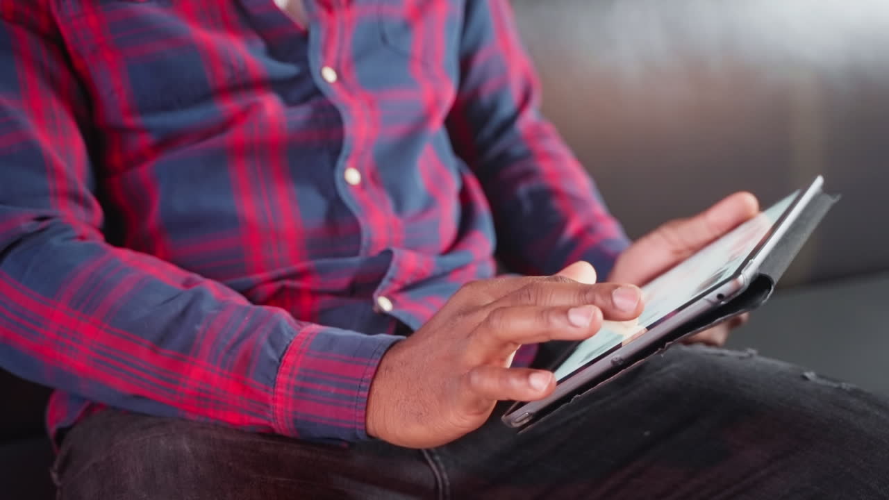 Man using a tablet in a plaid shirt
