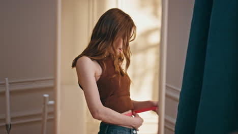 hands holding measuring tape in mirror reflection closeup. slim girl checking