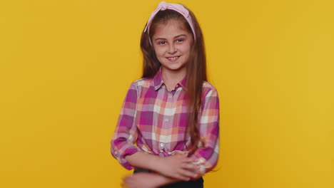 Cheerful-lovely-young-preteen-child-girl-kid-smiling,-looking-at-camera-on-studio-yellow-background