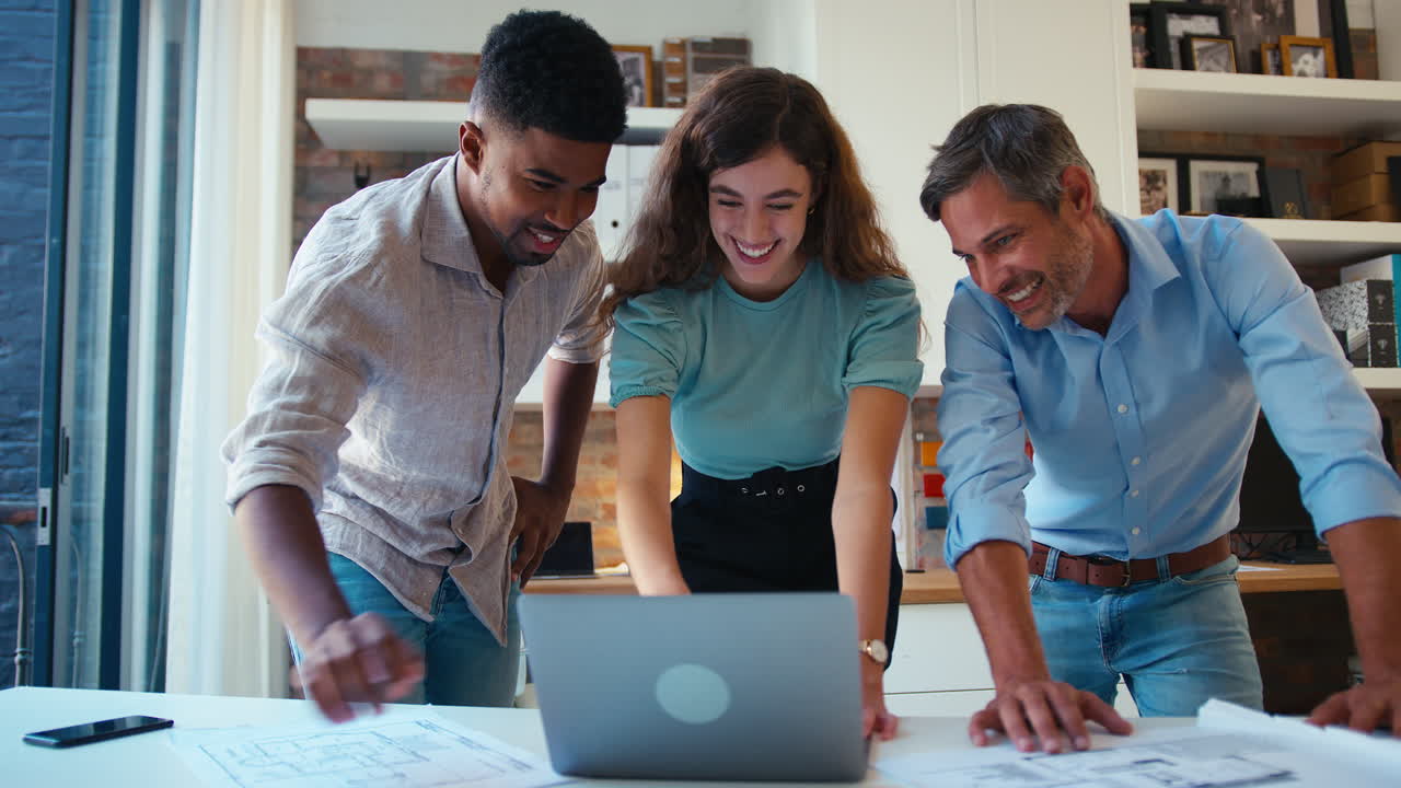 arquitectos masculinos y femeninos con computadoras portátiles se reúnen y discuten planes de construcción en una oficina moderna