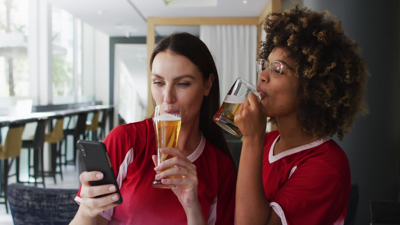 un grupo diverso de amigos felices viendo un juego bebiendo cervezas y tomando una selfie en un bar
