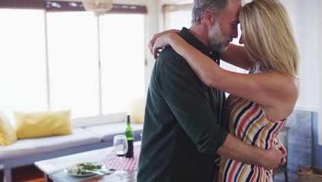 happy caucasian mature couple dancing in the sunny living room