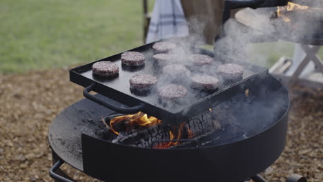 hamburgers cooking over a campfire