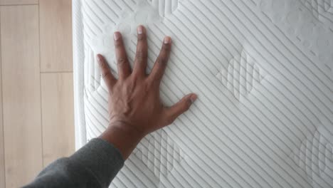 close up of a hand on a white mattress