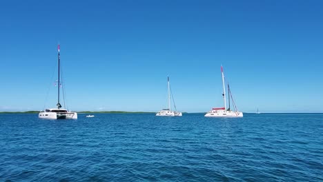 crystal clear caribbean sea with ancored catamarans, los roques archipelago