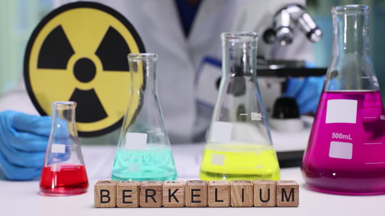 Laborant, tehlikeyi vurgulamak için radyasyon uyarı işaretini gösteriyor.