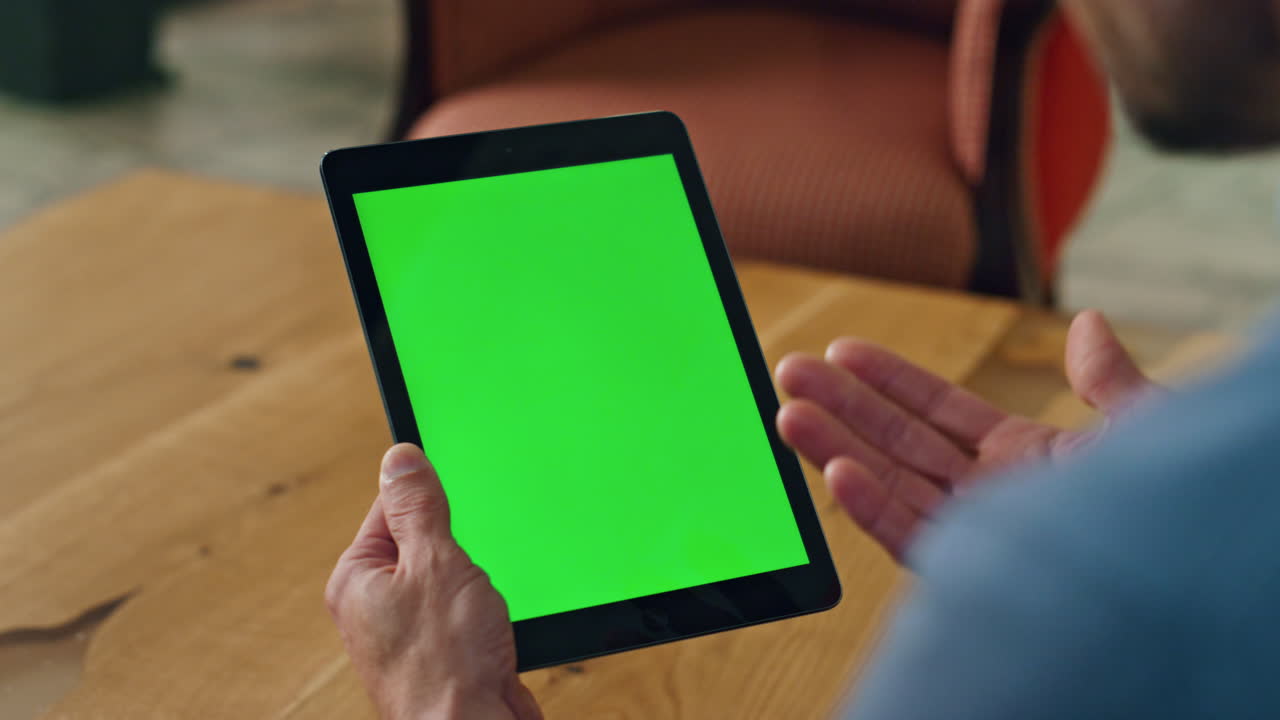 Gesturing man talking greenscreen tab indoors. closeup employee ...