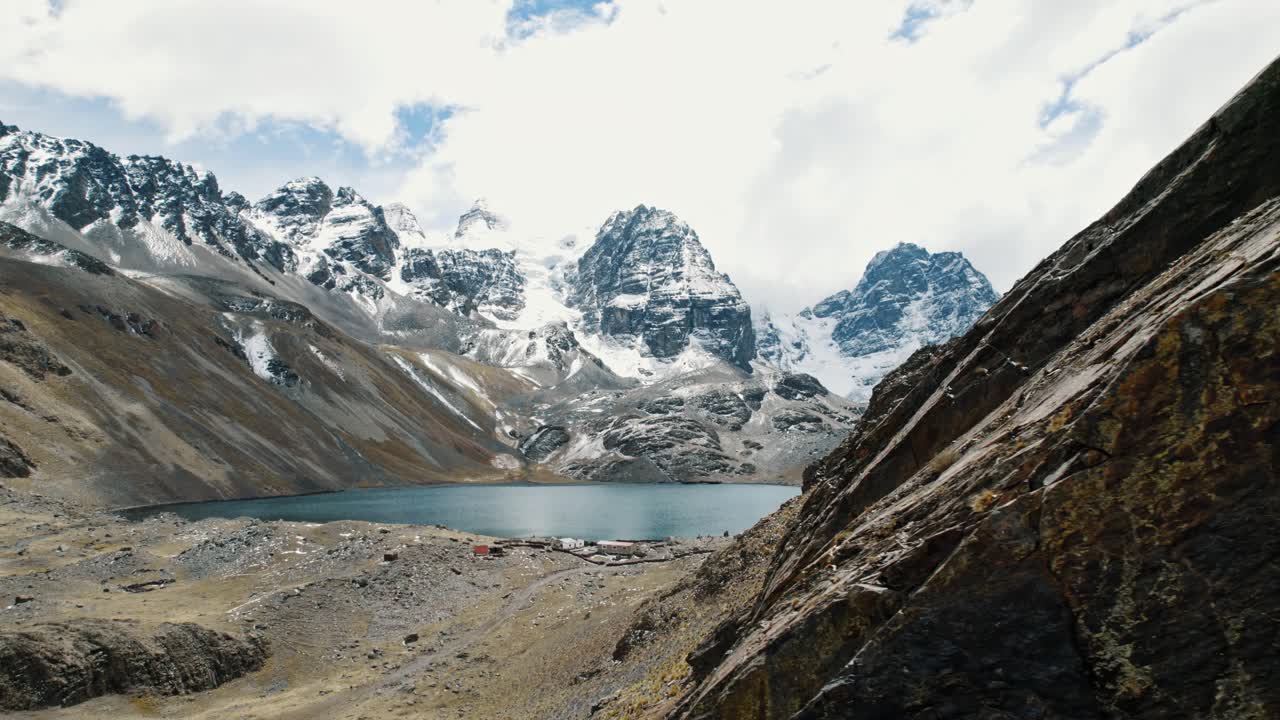 Un'ampia panoramica aerea del lago glaciale turchese di Chiarkhota ai piedi delle frastagliate cime andine. La maestosità ad alta quota della regione di Pico Austria in Bolivia