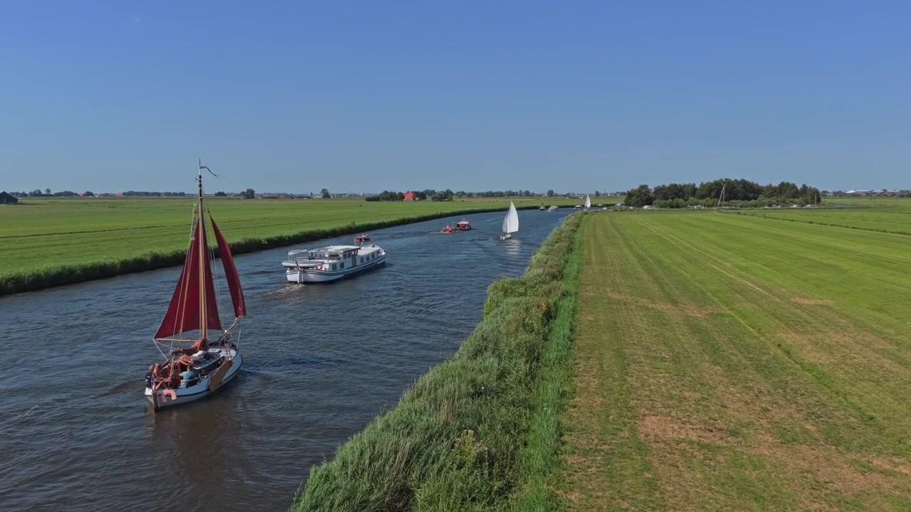 Barche che navigano lungo un canale panoramico nella campagna olandese